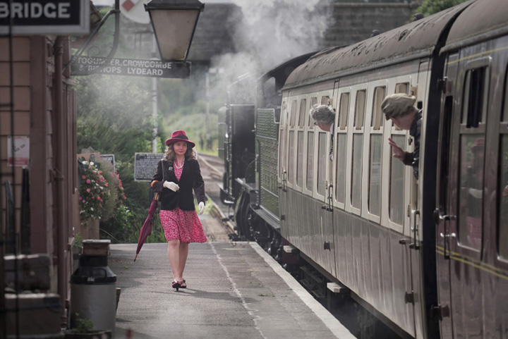 1940s Girl walks along a train platform next to a steam train